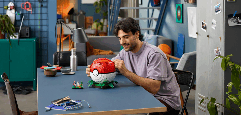 Person baut den LEGO Pokémon Pokéball mit Trainermomenten und den enthaltenen Minifiguren.